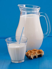 Milch in einem Krug vor blauem Hintergrund