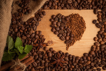 heart-shaped coffee beans and instant coffee on wooden table