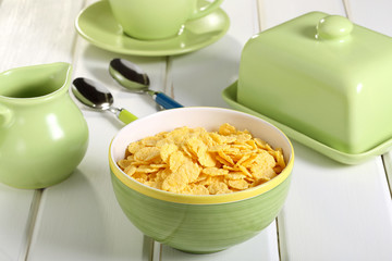 cereali di mais in tazza verde su tavolo bianco