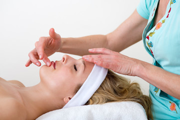 Masseuse massaging a woman lip area.