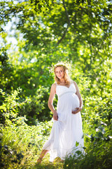 Fototapeta na wymiar Pregnant woman in green forest