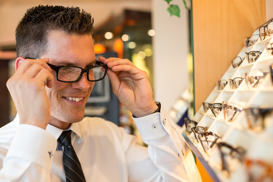 Kunde im Laden eines Optikers probiert Brille