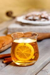 Glass of hot tea on rustic wooden table. Cozy home.