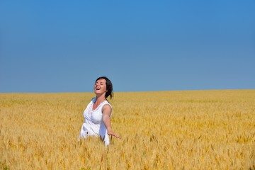 young woman in wheat field at summer