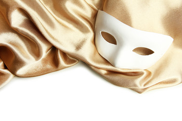 White mask and golden silk fabric, isolated on white