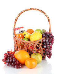 Different fruits in wicker basket with juice isolated on white
