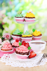 Beautiful cupcakes on dining table on natural background