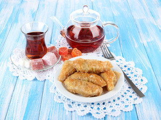 Sweet baklava on plate with tea on table