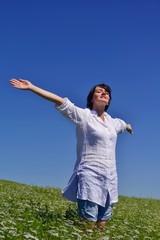 young woman with spreading arms to sky