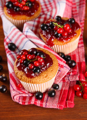 Tasty muffins with berries on wooden table