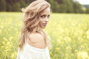 Fototapeta na wymiar Portrait of a sexy blond girl in a field