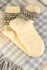 Warm knitted socks on plaid close-up