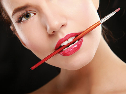 Woman's Lips Holding Make Up Brush