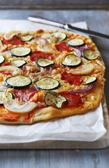 Pizza with zucchini, onion and salami
