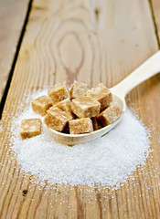 Sugar brown and granulated sugar in a spoon on the board
