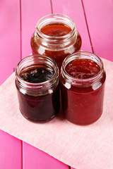 Tasty jam in banks on table