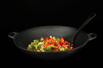 Vegetable ragout in wok, isolated on black