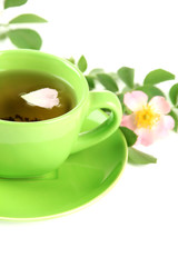 Cup of herbal tea with hip rose flowers, isolated on white