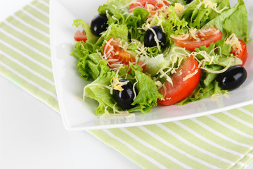 Light salad on plate on napkin  isolated on white