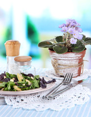 Light salad on plate on table on room background