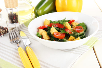 Light salad in plate on wooden table