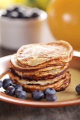 Stack of pancakes with blueberries and orange juice