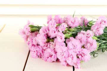 Many small pink cloves on wooden background