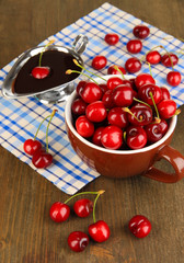 Ripe red cherry berries in cup and chocolate sauce