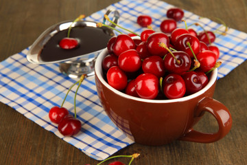 Ripe red cherry berries in cup and chocolate sauce