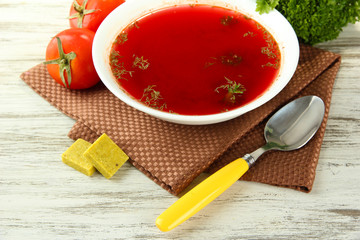 Bowl of soup with bouillon cubes on wooden table