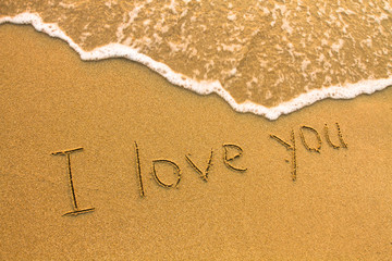 I love You - inscription on the beach sand, soft surf wave