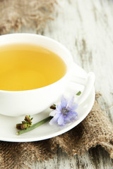Cup of tea with chicory, on wooden background