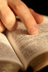 Fototapeta premium Close-up of Bible opened on Psalm 23 and pointing finger