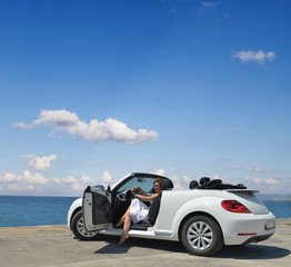 A woman in a white convertible