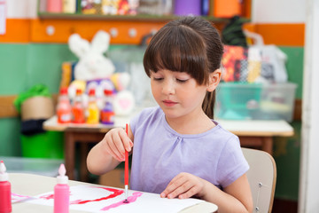 Girl Painting At Desk In Classroom