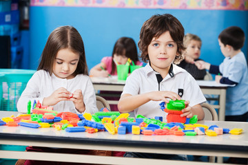Boy With Female Friend Playing Blocks In Kindergarten