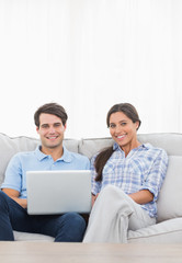 Portrait of a couple relaxing with a laptop