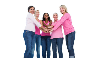 Obraz premium Cheerful women wearing breast cancer ribbons with hands together