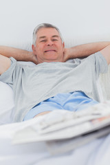 Cheerful man relaxing in bed