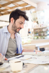 man at the bar reading newspaper