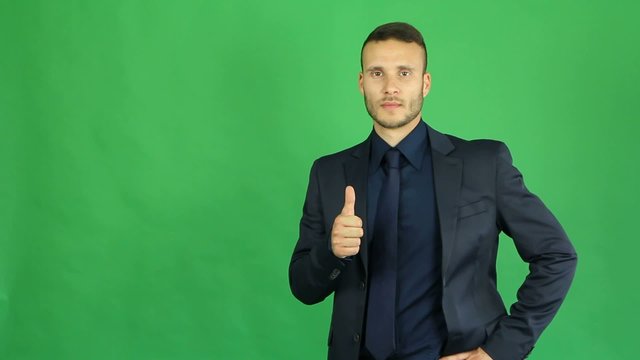 businessman with tumbs up on green