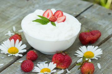 yogurt dessert with strawberries on old wooden background