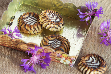 cookies in a box with purple flowers on burlap fabric