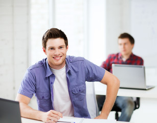 smiling student with laptop at school