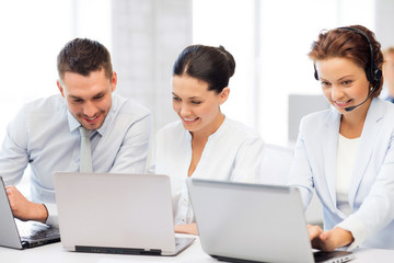 group of people working with laptops in office