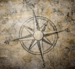 Old compass on paper background