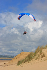 paraglider over sand dunes