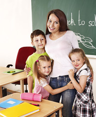 Children in classroom near blackboard.