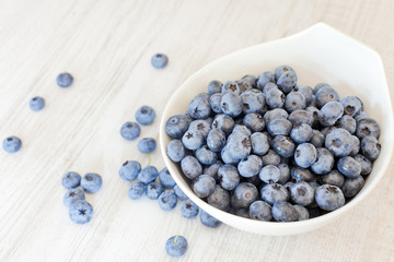 Fototapeta na wymiar White bowl cup with fresh ripe blueberries
