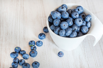 White bowl cup with fresh ripe blueberries